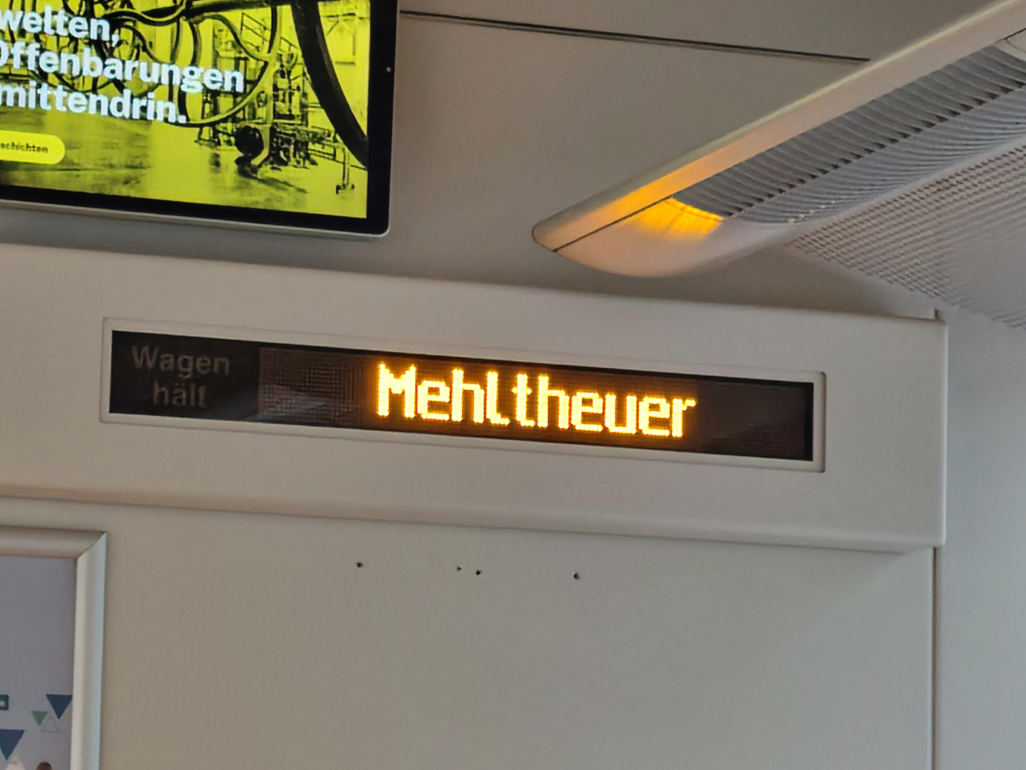 Stationsanzeige im Zug mit dem Wort "Mehltheuer" 